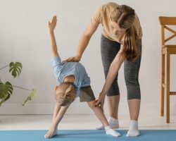 full-shot-woman-helping-kid-exercise yogateacherstraining